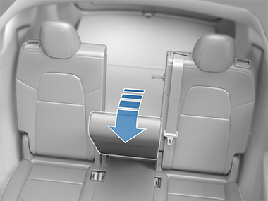 Center second row seat folded forward with arrow pointing down
