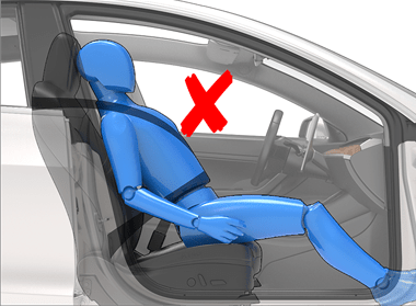 une personne assise au bord de son siège et une croix rouge