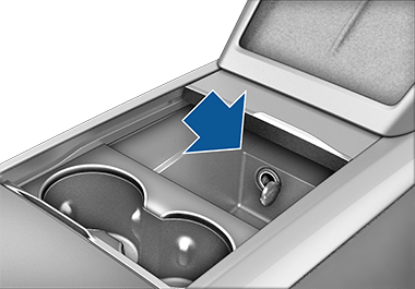 Mittkonsolen med lyft armstöd, visar eluttaget i facket